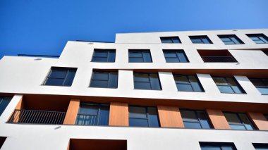 Modern ve yeni apartman. Çok katlı modern, yeni ve şık apartman daireleri. Parlak güneşli bir günde masmavi gökyüzünde güneş ışığıyla yüzler.