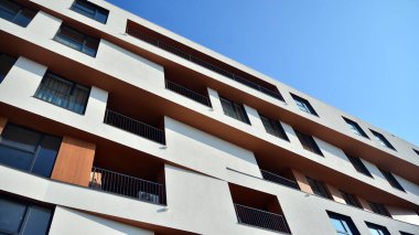 Modern ve yeni apartman. Çok katlı modern, yeni ve şık apartman daireleri. Parlak güneşli bir günde masmavi gökyüzünde güneş ışığıyla yüzler.