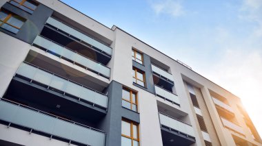 Modern çok katlı bir apartmanın dış cephesi, pencereleri ve balkonları..