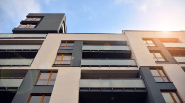 Modern çok katlı bir apartmanın dış cephesi, pencereleri ve balkonları..