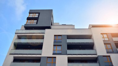 Modern çok katlı bir apartmanın dış cephesi, pencereleri ve balkonları..