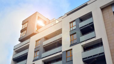 Modern çok katlı bir apartmanın dış cephesi, pencereleri ve balkonları..