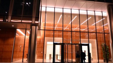 Ofis binalarının pencereleri gece aydınlandı. Şehir merkezinde yansıması olan cam mimari cephe tasarımı ile ışıklandırma.