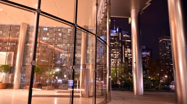 オフィスビルの窓のパターンは夜に点灯します 都市の反射とガラス建築のファサードデザインと照明 — ストック写真
