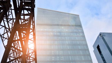 İş bölgesindeki modern ofis binalarının alt manzarası. Gökdelen cam cepheleri masmavi gökyüzünde güneş ışınlarıyla aydınlık bir günde.