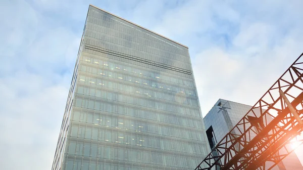 İş bölgesindeki modern ofis binalarının alt manzarası. Gökdelen cam cepheleri masmavi gökyüzünde güneş ışınlarıyla aydınlık bir günde.