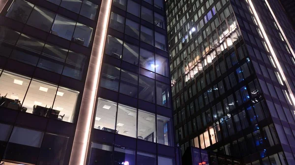 밤에는 사무용 건물의 창문이 조명되었다 양식에 비추어 도시에 반사되어 — 스톡 사진