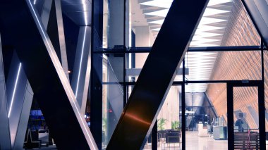 Ofis binalarının pencereleri gece aydınlandı. Şehir merkezinde yansıması olan cam mimari cephe tasarımı ile ışıklandırma.