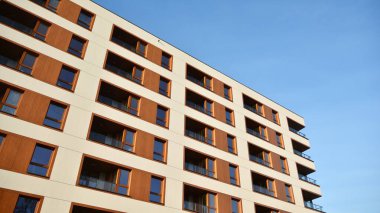 Yeni apartman cephesi. Cam balkon ve mavi gökyüzü arka planlı modern mimari binasının temiz görüntüsü..