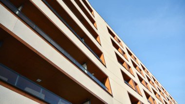 Yeni apartman cephesi. Cam balkon ve mavi gökyüzü arka planlı modern mimari binasının temiz görüntüsü..