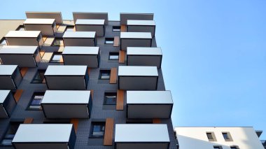 Balkonları olan modern bir apartmanın ön cephesi. İnsan yok. Emlak işi kavramı.