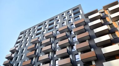 Balkonları olan modern bir apartmanın ön cephesi. İnsan yok. Emlak işi kavramı.