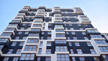 Balkonları olan modern bir apartmanın ön cephesi. İnsan yok. Emlak işi kavramı.