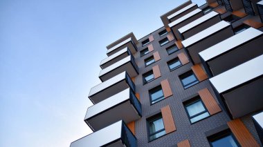 Balkonları olan modern bir apartmanın ön cephesi. İnsan yok. Emlak işi kavramı.