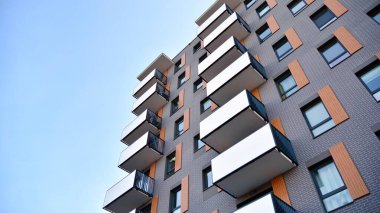 Balkonları olan modern bir apartmanın ön cephesi. İnsan yok. Emlak işi kavramı.