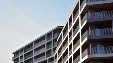 Balkonları olan modern bir apartmanın ön cephesi. İnsan yok. Emlak işi kavramı.