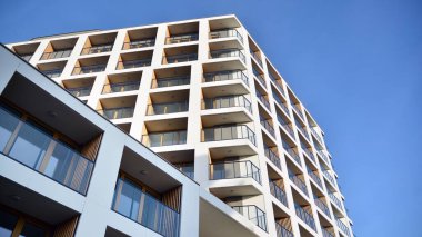 Yeni apartman cephesi. Cam balkon ve mavi gökyüzü arka planlı modern mimari binasının temiz görüntüsü..