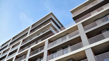 Balkonları olan modern bir apartmanın ön cephesi. İnsan yok. Emlak işi kavramı.