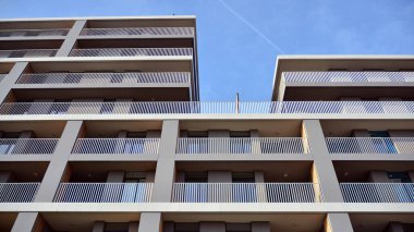 Balkonları olan modern bir apartmanın ön cephesi. İnsan yok. Emlak işi kavramı.