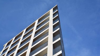 Yeni apartman cephesi. Cam balkon ve mavi gökyüzü arka planlı modern mimari binasının temiz görüntüsü..