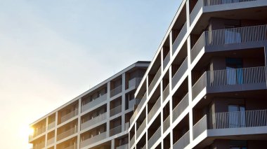 Apartman, ev ve dış görünüş mimarisi ve açık hava tesisleri. Arka planda mavi gökyüzü. Güneş ışığı