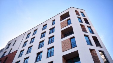 Modern lüks apartman dairesi, ev inşa konsepti. Güneşli bir günde, mavi gökyüzü olan modern bir apartman..