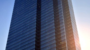 Gayrimenkul ve şirket inşaatı kavramı gökyüzünde turuncu sabah güneşinin modern ofis binası..