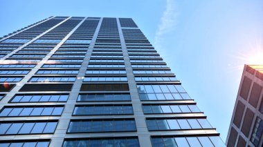 Gayrimenkul ve şirket inşaatı kavramı gökyüzünde turuncu sabah güneşinin modern ofis binası..