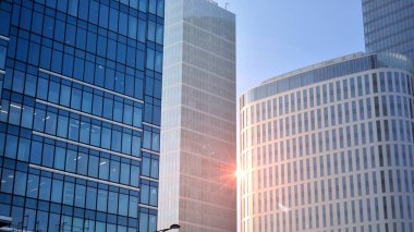 Gayrimenkul ve şirket inşaatı kavramı gökyüzünde turuncu sabah güneşinin modern ofis binası..