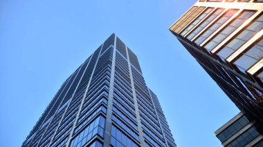 Gayrimenkul ve şirket inşaatı kavramı gökyüzünde turuncu sabah güneşinin modern ofis binası..