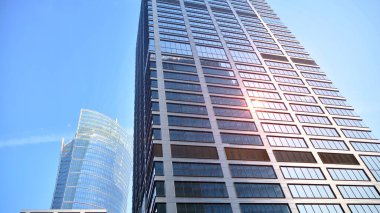 Gayrimenkul ve şirket inşaatı kavramı gökyüzünde turuncu sabah güneşinin modern ofis binası..