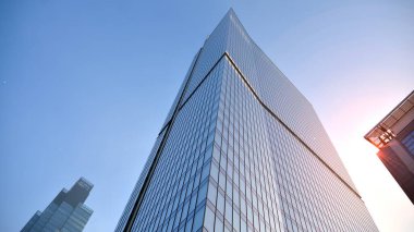 Gayrimenkul ve şirket inşaatı kavramı gökyüzünde turuncu sabah güneşinin modern ofis binası..