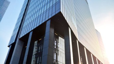 Gayrimenkul ve şirket inşaatı kavramı gökyüzünde turuncu sabah güneşinin modern ofis binası..