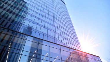 Gayrimenkul ve şirket inşaatı kavramı gökyüzünde turuncu sabah güneşinin modern ofis binası..