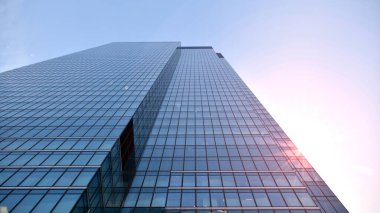 Gayrimenkul ve şirket inşaatı kavramı gökyüzünde turuncu sabah güneşinin modern ofis binası..