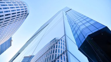 Mavi gökyüzü olan binaların cam cephesi. Şehir merkezindeki gökdelenler modern cam binaların arka planı.. 