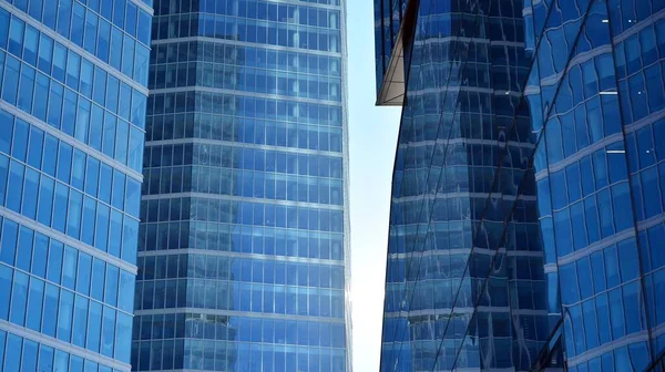 Glass facade of the buildings with a blue sky. Skyscrapers in the business city center.. Background of modern glass buildings.