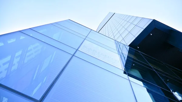 Glass facade of the buildings with a blue sky. Skyscrapers in the business city center.. Background of modern glass buildings.