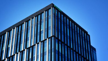 Mavi gökyüzü olan binaların cam cephesi. Şehir merkezindeki gökdelenler modern cam binaların arka planı.. 