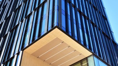 Mavi gökyüzü olan binaların cam cephesi. Şehir merkezindeki gökdelenler modern cam binaların arka planı.. 