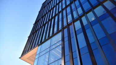 Mavi gökyüzü olan binaların cam cephesi. Şehir merkezindeki gökdelenler modern cam binaların arka planı.. 