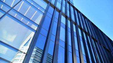 Mavi gökyüzü olan binaların cam cephesi. Şehir merkezindeki gökdelenler modern cam binaların arka planı.. 