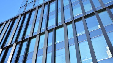 Mavi gökyüzü olan binaların cam cephesi. Şehir merkezindeki gökdelenler modern cam binaların arka planı.. 