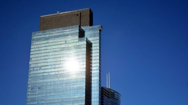 Mavi gökyüzü olan binaların cam cephesi. Şehir merkezindeki gökdelenler modern cam binaların arka planı.. 
