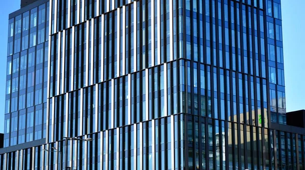 Glass facade of the buildings with a blue sky. Skyscrapers in the business city center.. Background of modern glass buildings.