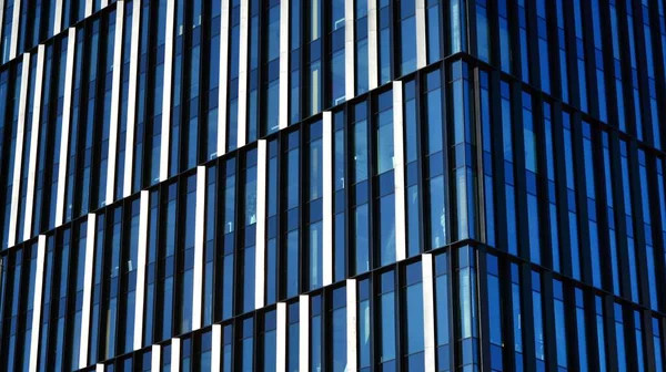 Glass facade of the buildings with a blue sky. Skyscrapers in the business city center.. Background of modern glass buildings.