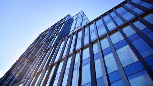 Glass facade of the buildings with a blue sky. Skyscrapers in the business city center.. Background of modern glass buildings.