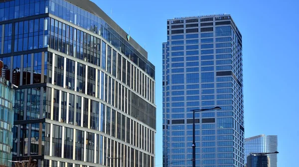 Glass facade of the buildings with a blue sky. Skyscrapers in the business city center.. Background of modern glass buildings.