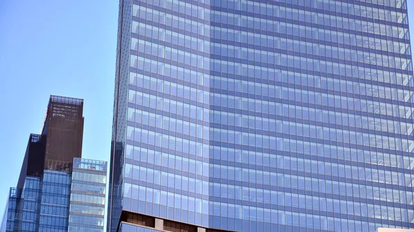 青い空の建物のガラスのファサード ビジネス街の中心部にある高層ビル現代的なガラスの建物の背景 — ストック写真