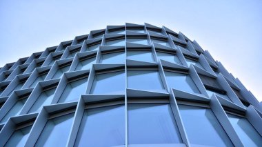 Camdan yapılmış bir ofis binasının parçası. Mavi gökyüzünün yansıması. 